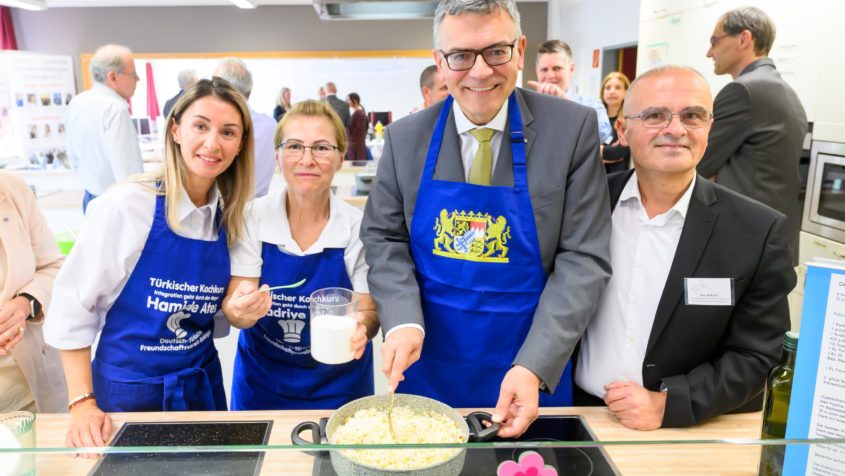 Staatsminister Dr. Florian Herrmann (2. von rechts) beim t&uuml;rkischen Kochkurs &bdquo;Integration geht durch den Magen&ldquo; des Deutsch-T&uuml;rkischen Freundschaftsvereins Bobingen e. V. in der Mittelschule Bobingen.