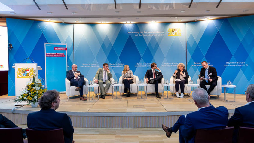 Sechs Personen diskutieren auf einem Podium miteinander. Im ...