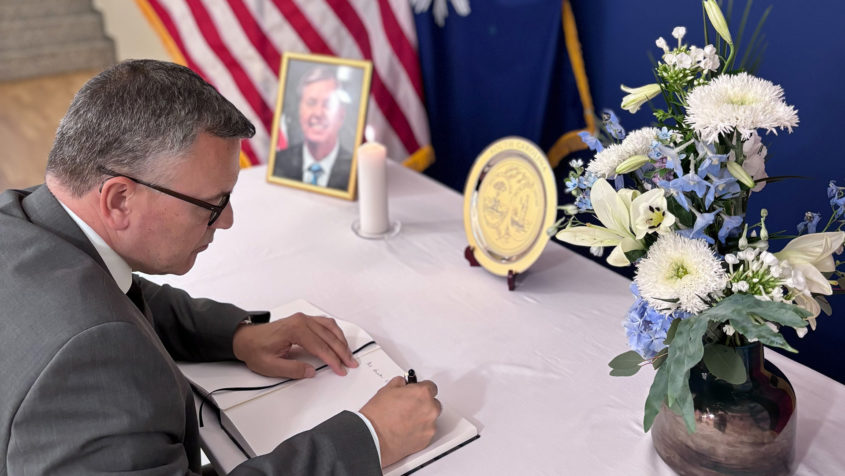 Staatsminister Dr. Florian Herrmann trägt sich in das Kondolenzbuch für den verstorbenen US-Senator Lindsey Graham ein.